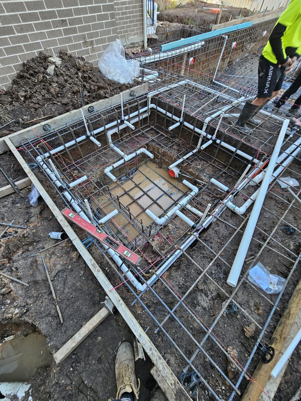 Spa steelwork and plumbing set out beside a brick house